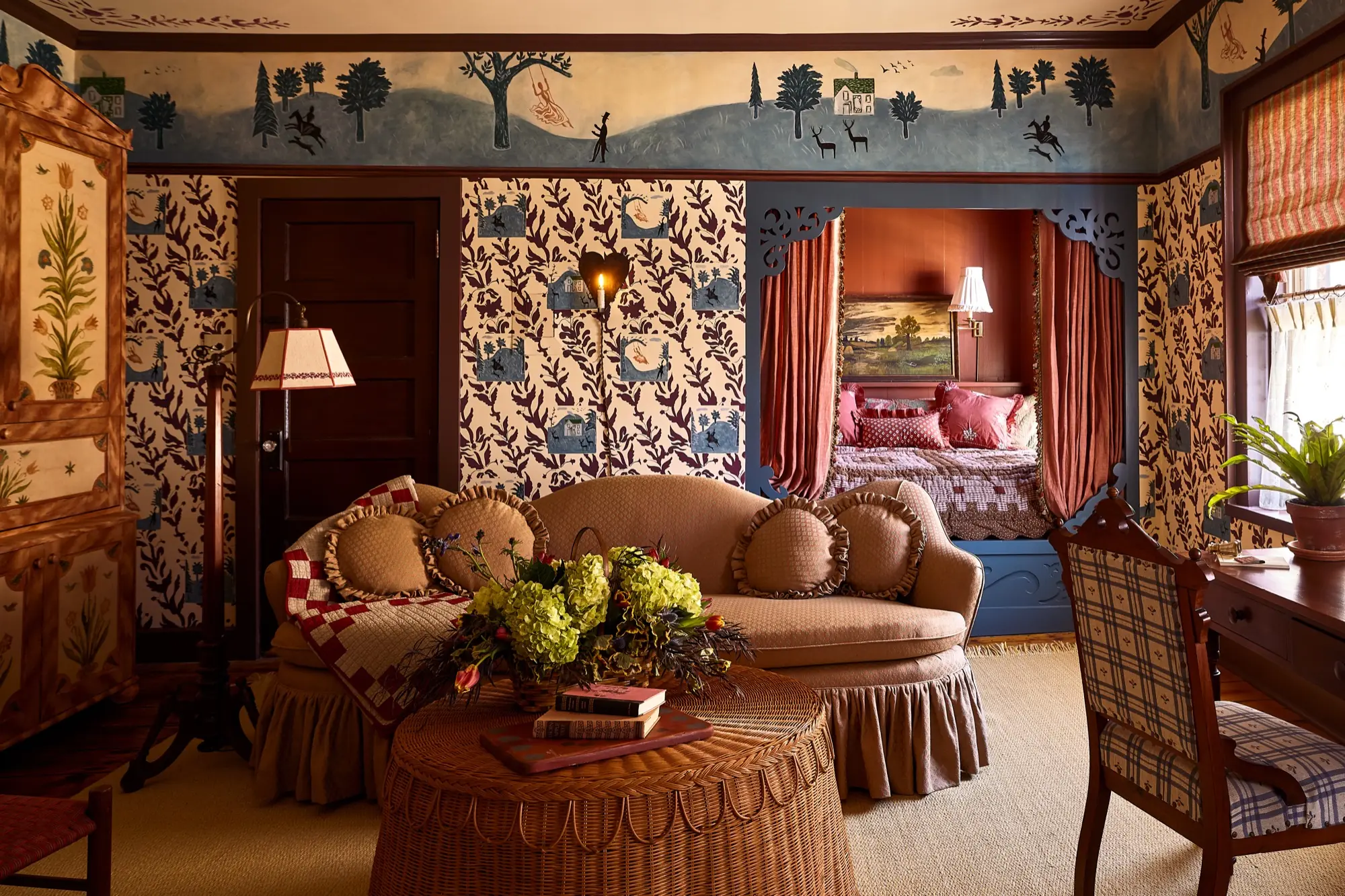 Designer suite at The Six Bells in Rosendale, with a curtained alcove bed, hand-painted folk mural, patterned wallpaper, and antique furnishings.